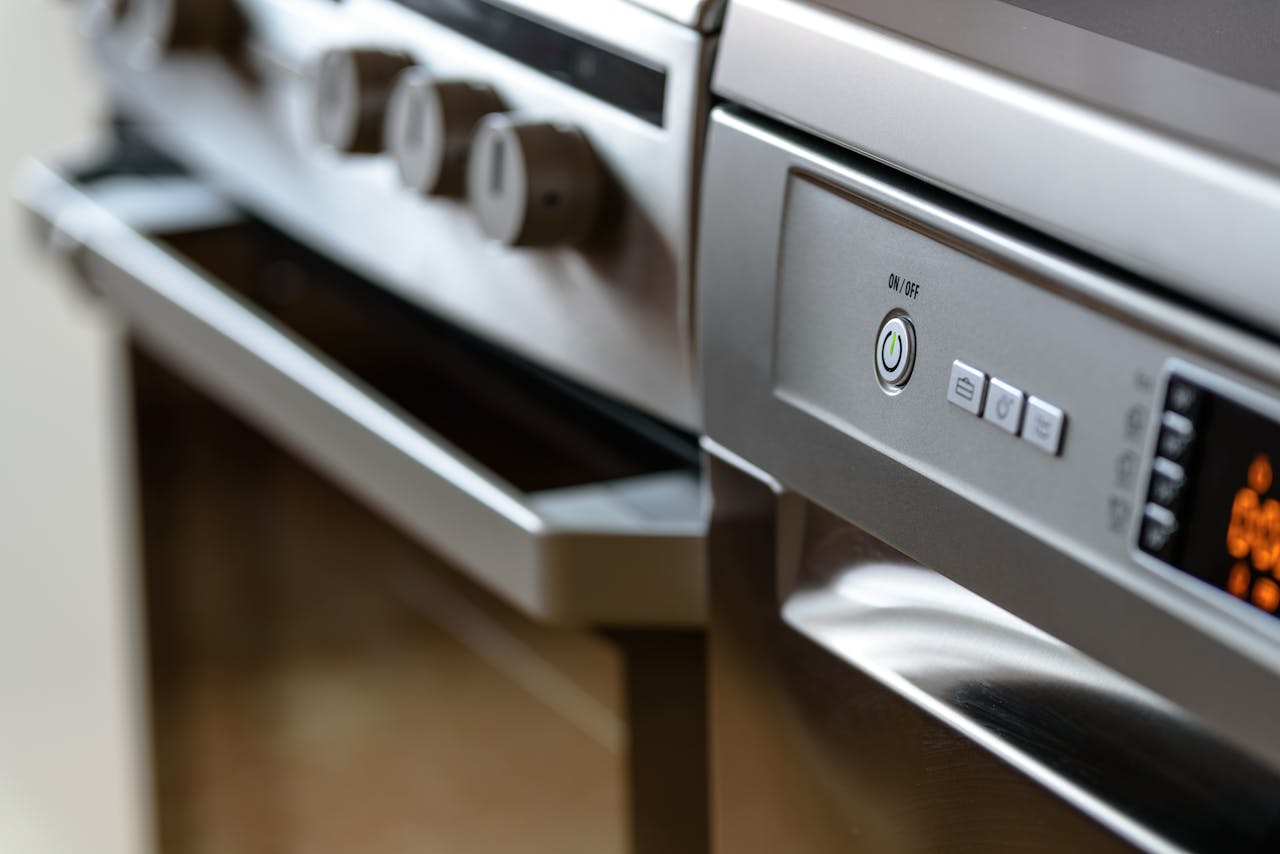 The Art of Drawing Readers In: Your attractive post title goes here Close-up view of modern stainless steel kitchen appliances with focus on dishwasher and oven.